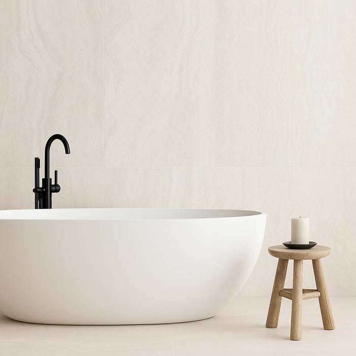 Luxurious bathroom with Appia Vein Cut White Matte 24 x 48 tiles, freestanding white tub, and candle on wooden stool.