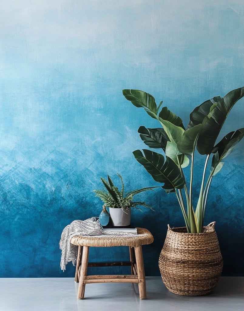 Blue color tile ombré backdrop with wicker stool and lush plant.