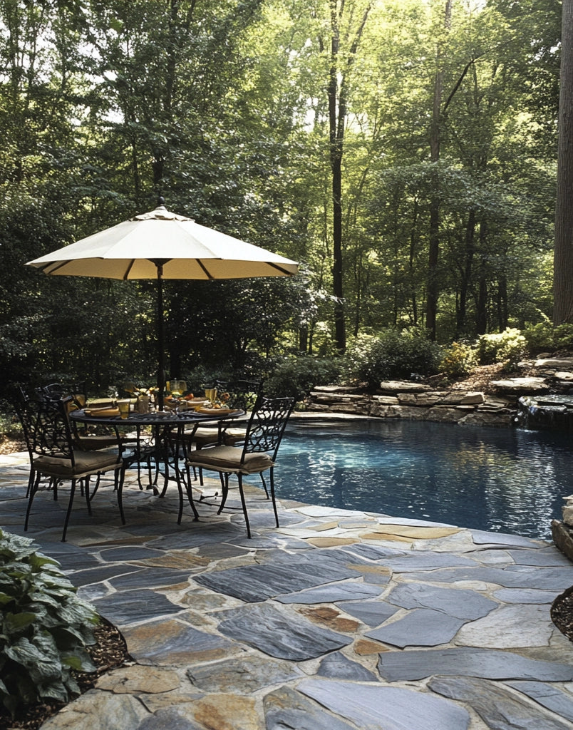 Outdoor patio with natural stone–look flagstone tile around pool and forested backdrop.
